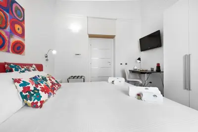 a white bedroom with a large white bed with pillows at White in Palermo
