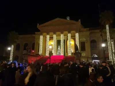 a crowd of people in front of a building at night at Casa Del Vicolo Apartament in Palermo