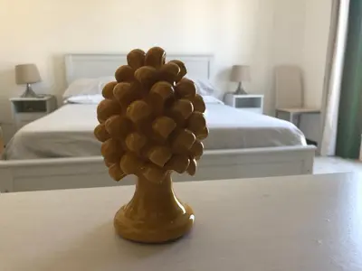a gold vase with a bunch of grapes on a table at Cosmopolitan Palermo in Palermo