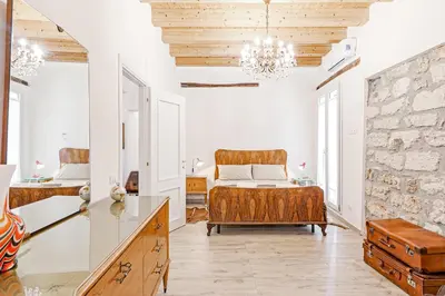 a bedroom with a bed and a stone wall at GuestHost - Palazzo dei Normanni Stylish Apartment in Palermo