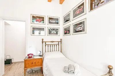 a bedroom with a bed and pictures on the wall at GuestHost - Palazzo dei Normanni Stylish Apartment in Palermo