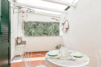 a patio with a table and chairs and a window at GuestHost - Palazzo dei Normanni Stylish Apartment in Palermo