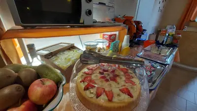 a table with a pizza and fruits on a counter at La Suite Di Segesta in Calatafimi