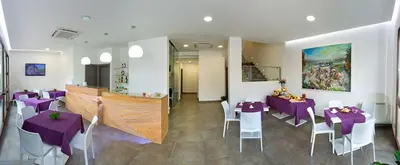 a dining room with purple tables and white chairs at Le Camere del Crimiso in Castellammare del Golfo