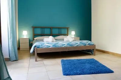 a bedroom with a bed with a blue wall at Bahlara Case Vacanza in Palermo