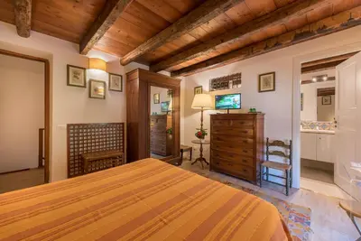 a bedroom with a bed and a dresser and a television at Il Glicine La Piana dei Colli in Mondello