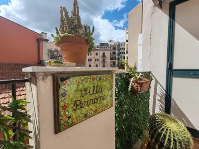 a row of cars parked on a street with trees at 4 passi Casa Vacanza in Palermo