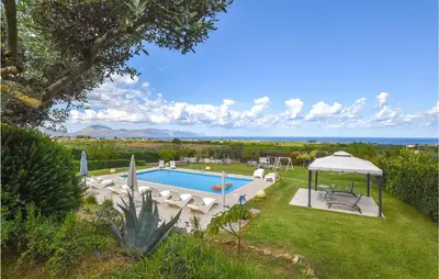 a swimming pool with chairs and a gazebo at Villa Musasealdoge in Partinico