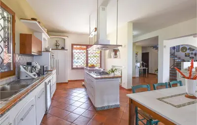 a kitchen with white cabinets and a counter top at Villa Musasealdoge in Partinico