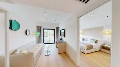 a large white room with a bed and a couch at The Signature Level at Grand Palladium Sicilia Resort & Spa in Campofelice di Roccella