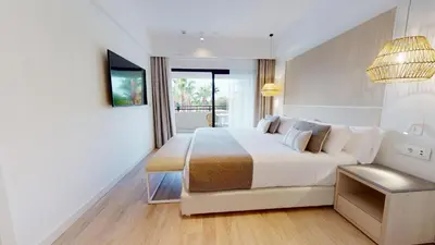 a bedroom with a large white bed and a window at The Signature Level at Grand Palladium Sicilia Resort & Spa in Campofelice di Roccella