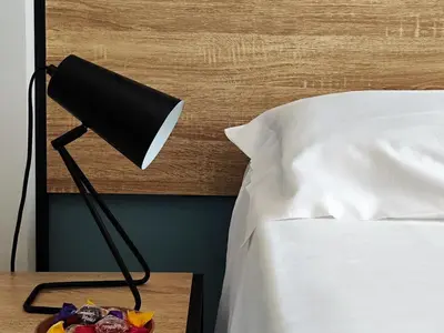 a lamp on a night stand next to a bed at Bed & Breakfast Tiziana in Castellammare del Golfo
