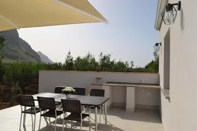 a patio with a table and chairs and a counter at La Giara San Vito Lo Capo in Castelluzzo