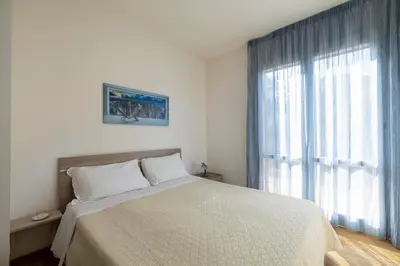 a bedroom with a bed and a large window at Casa Vacanza Azzurra in San Vito lo Capo