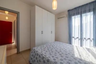 a bedroom with a bed and a large window at Casa Vacanza Azzurra in San Vito lo Capo