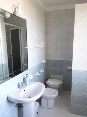 a bathroom with a sink and a toilet and a mirror at Casa vacanze Isolotto in Isola delle Femmine
