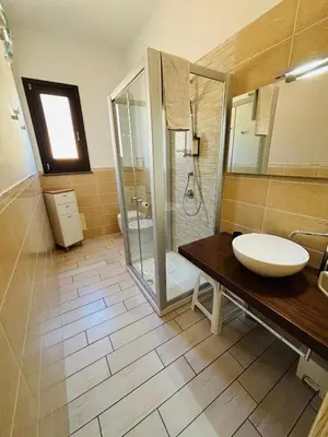 a bathroom with a sink and a glass shower at Triskell Camere & Relax in Castelluzzo