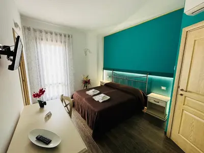 a hotel room with a bed and a table and a desk at Triskell Camere & Relax in Castelluzzo