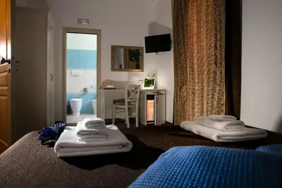 a bedroom with towels on a bed and a desk at Triskell Camere & Relax in Castelluzzo