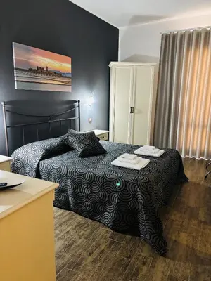 a bedroom with a bed with a black comforter at Triskell Camere & Relax in Castelluzzo