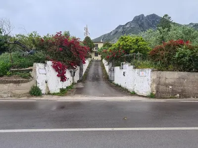 a road with a house with flowers on the wall at Villa Calcasacco in Termini Imerese