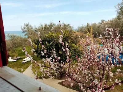 a tree with pink flowers in a garden at Villa Calcasacco in Termini Imerese