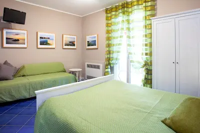 a bedroom with two beds and a couch at TerraSole Bakery B&B in Terrasini