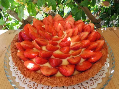 a cake with strawberries on top of it on a table at TerraSole Bakery B&B in Terrasini