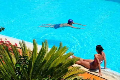 two people are swimming in a swimming pool at Villa Dafne in Alia