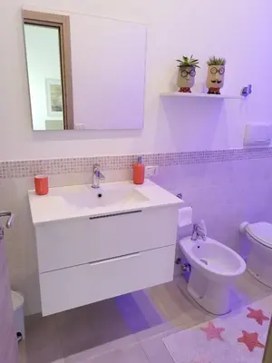 a bathroom with a sink and a toilet and a mirror at Alcamo Rooms con GARAGE privato in Alcamo