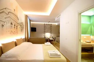 a hotel room with a bed and a desk at BURNÌA Sicily Holiday House in Palermo