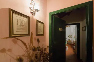 a hallway with a green door and pictures on the wall at Masseria Pernice in Monreale