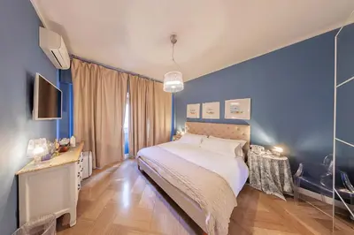 a bedroom with a large bed with blue walls at Maison de Famille in Palermo