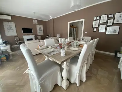a dining room with a table and white chairs at Maison de Famille in Palermo
