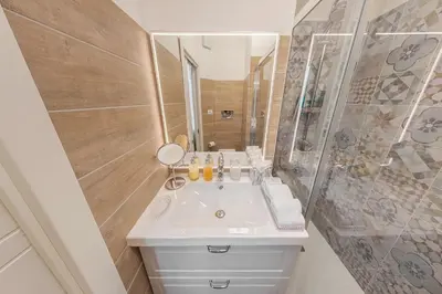 a bathroom with a white sink and a shower at Maison de Famille in Palermo