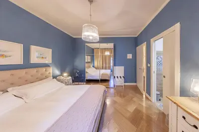 a bedroom with blue walls and a large bed at Maison de Famille in Palermo