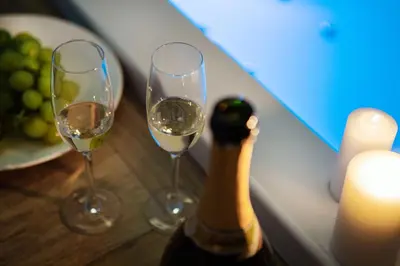 two glasses of white wine next to a bottle of champagne at Lighea aqua suites and breakfast in Palermo
