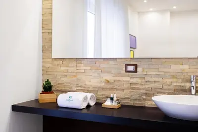 a bathroom with a sink and a counter with towels at Lighea aqua suites and breakfast in Palermo