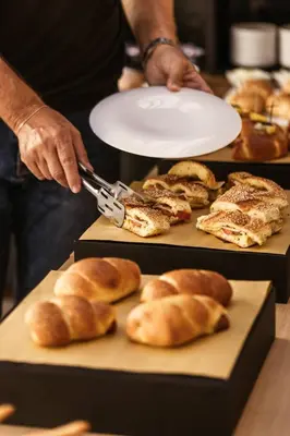 a person using a pair of scissors to cut bread at Hotel Tannure in San Vito lo Capo