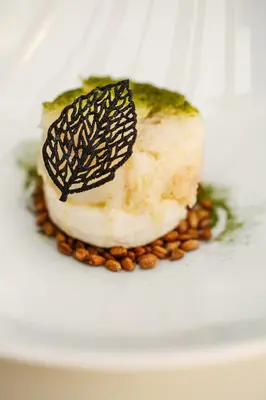 a piece of food on a white plate with nuts at Hotel Tannure in San Vito lo Capo