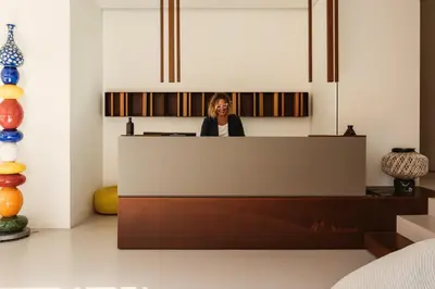 a woman standing behind a counter in a room at Hotel Tannure in San Vito lo Capo