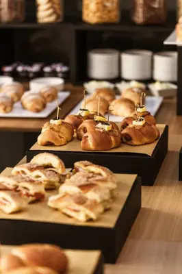 a bunch of pastries on plates on a table at Hotel Tannure in San Vito lo Capo