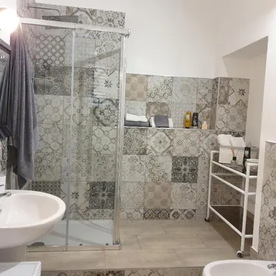 a shower with a glass door in a bathroom at Opera Prima 28 in Palermo
