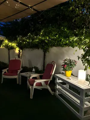 two chairs and a table on a patio with lights at Alemar Bed & Breakfast in Mondello