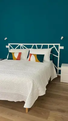 a bedroom with a white bed with a blue wall at Alemar Bed & Breakfast in Mondello