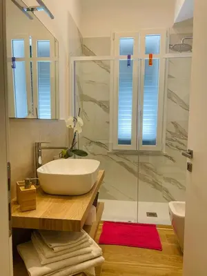 a bathroom with a sink and a glass shower at Alemar Bed & Breakfast in Mondello