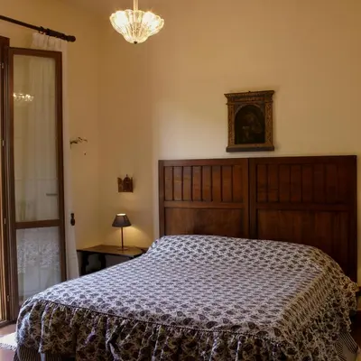a bedroom with a large bed and a chandelier at Agriturismo Ridocco in Corleone
