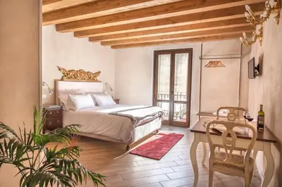 a bedroom with a bed and a table and chairs at Conte Federico Apartments in Palermo