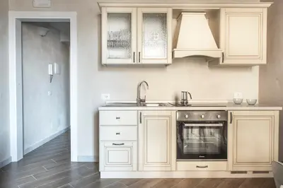 a kitchen with white cabinets and a sink at Conte Federico Apartments in Palermo