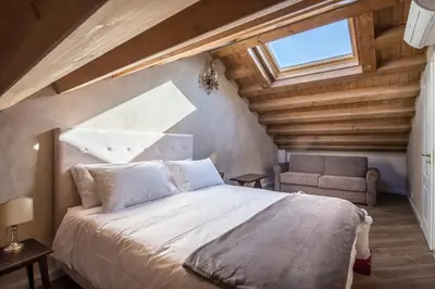 a bedroom with a large bed and a chair at Conte Federico Apartments in Palermo